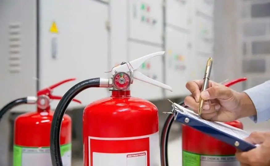 Extintores de incêndio sendo conferidos com uma prancheta